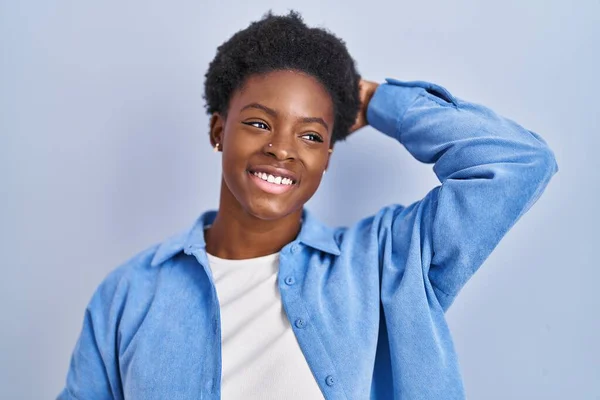 African American Woman Standing Blue Background Smiling Confident Touching Hair — Photo