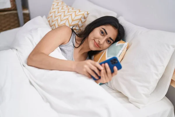 Young Hispanic Girl Using Smartphone Lying Bed Bedroom — Zdjęcie stockowe