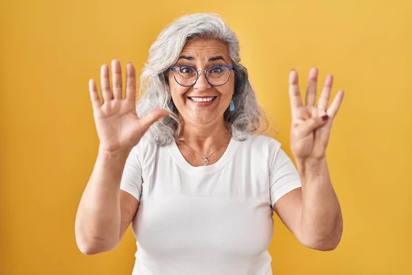 Sarı Arka Planda Gri Saçlı Orta Yaşlı Bir Kadın Dokuz — Stok fotoğraf