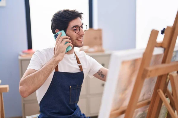 Young Hispanic Man Artist Talking Smartphone Drawing Art Studio — ストック写真