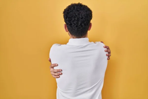 Άραβας Που Στέκεται Πάνω Από Κίτρινο Φόντο Αγκαλιάζοντας Τον Εαυτό — Φωτογραφία Αρχείου