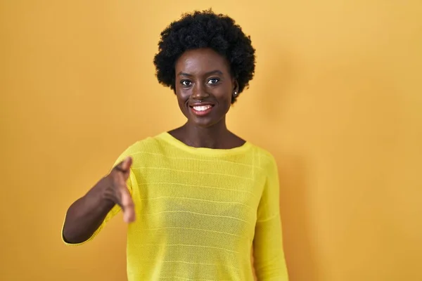 Afrikaanse Jonge Vrouw Staat Gele Studio Glimlachend Vriendelijk Aanbieden Van — Stockfoto