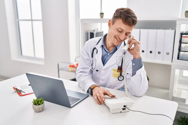 Jovem Médico Usando Laptop Falando Telefone Clínica — Fotografia de Stock
