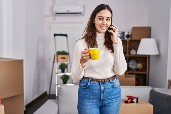 Young Beautiful Hispanic Woman Talking Smartphone Drinking Coffee New Home — Stock Fotó