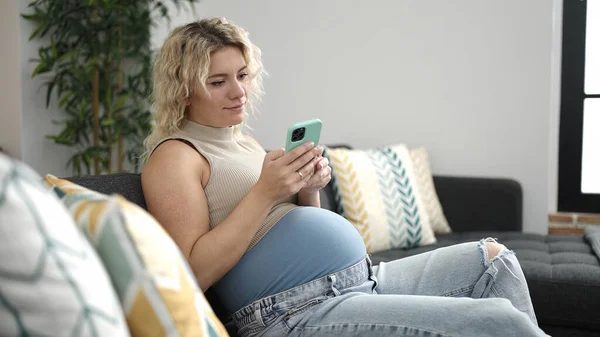 Νεαρή Έγκυος Γυναίκα Χρησιμοποιώντας Smartphone Αγγίζοντας Την Κοιλιά Στο Σπίτι — Φωτογραφία Αρχείου