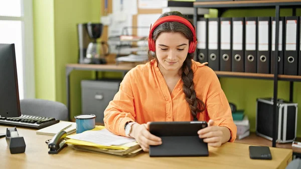 Νεαρή Όμορφη Ισπανόφωνη Επιχειρηματίας Χρησιμοποιώντας Touchpad Και Ακουστικά Στο Γραφείο — Φωτογραφία Αρχείου