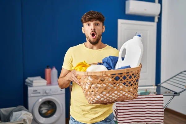 拿着洗衣篮和洗涤剂瓶子的阿拉伯男人害怕 恐惧和兴奋的表情 — 图库照片