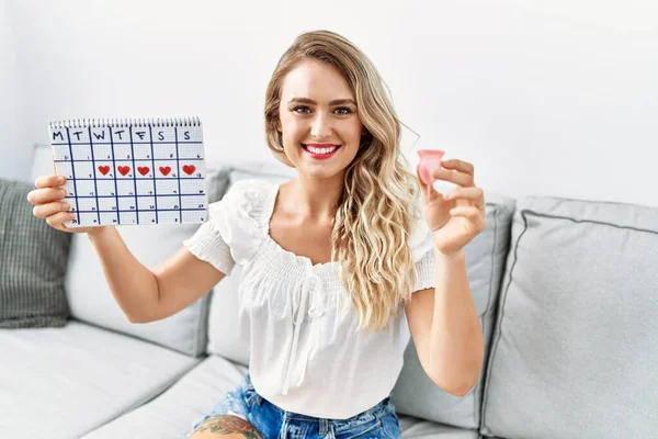 Young Woman Holding Menstrual Cup Period Calendar Sitting Sofa Home — Stok fotoğraf