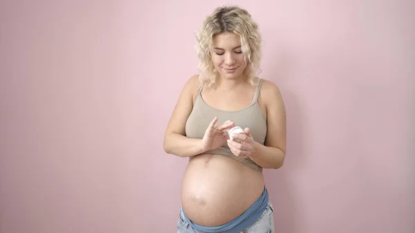 Mujer Embarazada Joven Sonriendo Confiada Aplicando Loción Para Cuidado Piel —  Fotos de Stock