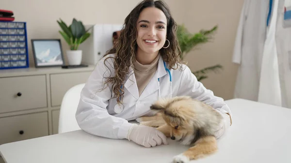 年轻的惊慌失措的女人 带着狗兽医的微笑 在诊所充满自信 — 图库照片