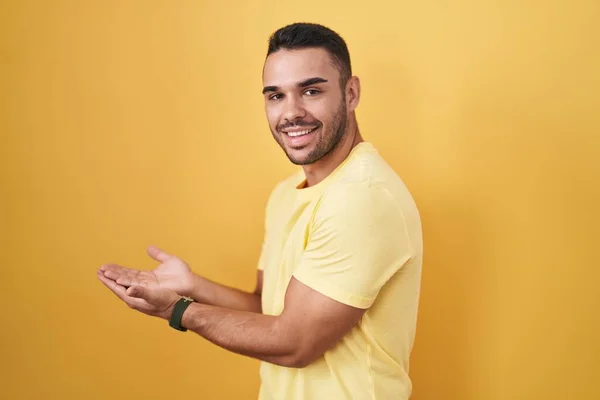 Young Hispanic Man Standing Yellow Background Pointing Aside Hands Open — 스톡 사진