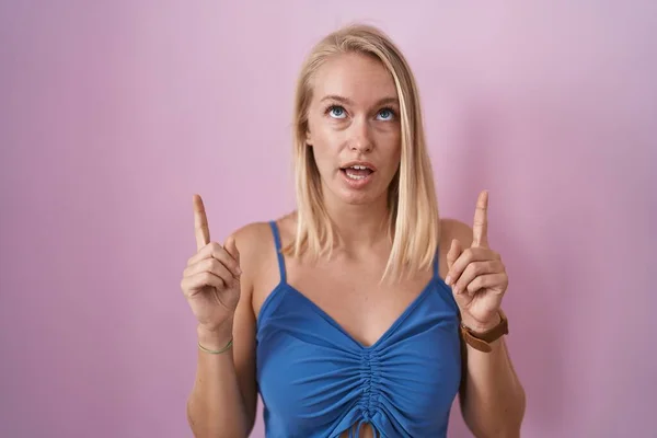 Young Caucasian Woman Standing Pink Background Amazed Surprised Looking Pointing — Foto Stock