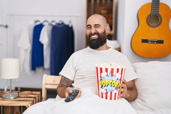 Ung Latinamerikansk Man Med Skägg Och Tatueringar Äter Popcorn Sängen — Stockfoto