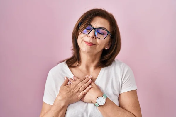 Middle Age Hispanic Woman Standing Pink Background Smiling Hands Chest — Stock Photo, Image