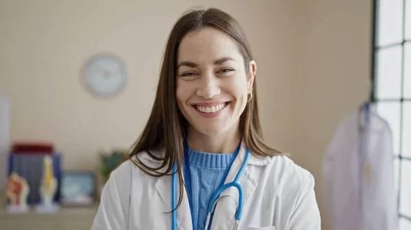 Νεαρή Καυκάσια Γυναίκα Γιατρός Χαμογελά Αυτοπεποίθηση Στέκεται Στην Κλινική — Φωτογραφία Αρχείου