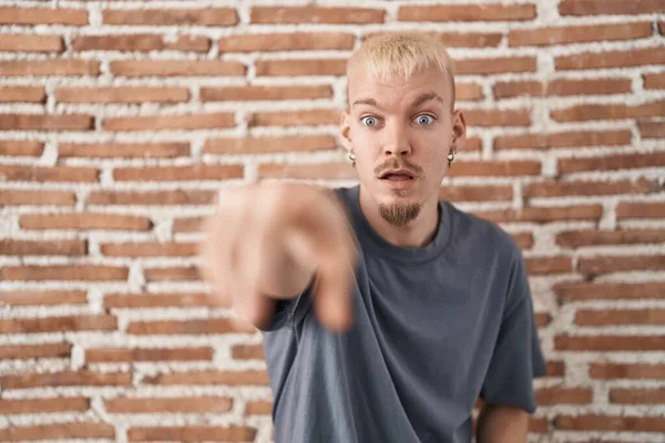 Joven Hombre Caucásico Pie Sobre Pared Ladrillos Señalando Con Dedo —  Fotos de Stock