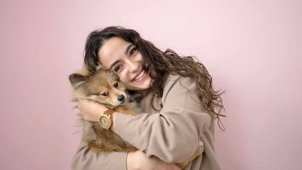 Junge Hispanische Frau Mit Hund Lächelt Selbstbewusst Vor Isoliertem Rosa — Stockfoto
