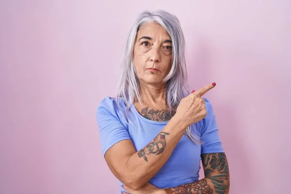Mulher Meia Idade Com Tatuagens Sobre Fundo Rosa Apontando Com — Fotografia de Stock