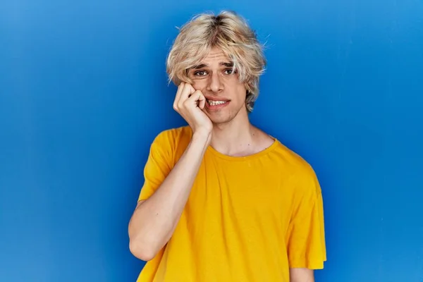 Joven Hombre Moderno Pie Sobre Fondo Azul Mirando Estresado Nervioso —  Fotos de Stock