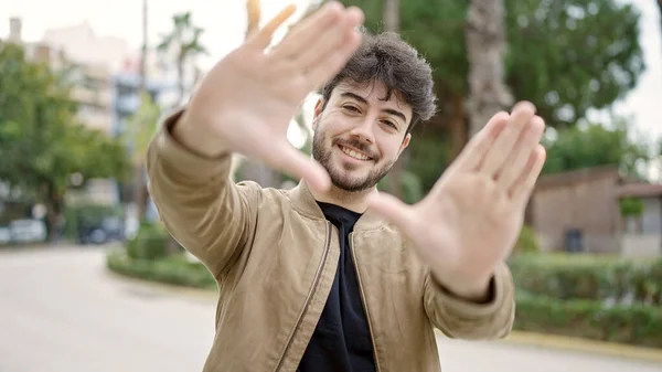 Joven Hombre Hispano Sonriendo Confiado Haciendo Gesto Marco Con Las —  Fotos de Stock