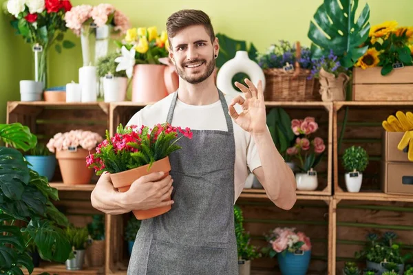 Hiszpan Brodą Pracujący Kwiaciarni Trzymający Roślinę Robi Znak Palcami Uśmiechając — Zdjęcie stockowe