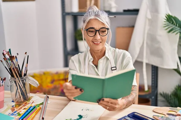 Middle Age Grey Haired Woman Artist Smiling Confident Reading Book — Stock Photo, Image