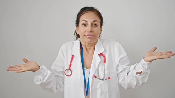 中世のヒスパニック女性医師立っていますClueless上の隔離された白い背景 — ストック写真