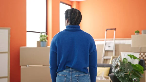 African american woman standing on back view at new home