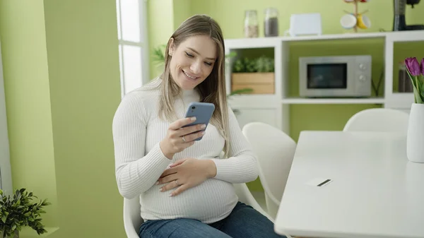 Genç Hamile Bir Kadın Yemek Odasında Akıllı Telefon Kullanıyor — Stok fotoğraf