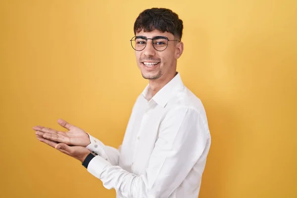 Young Hispanic Man Standing Yellow Background Pointing Aside Hands Open — Stock fotografie