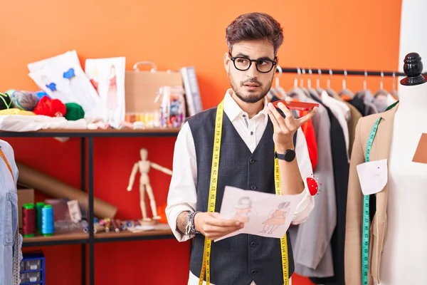 Young Hispanic Man Tailor Talking Smartphone Looking Clothing Design Atelier — Stockfoto