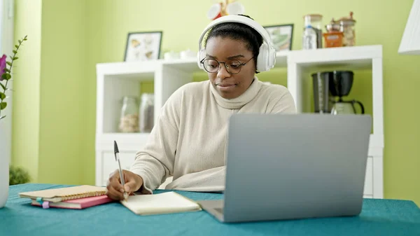 Afroamerykanka Używająca Laptopa Słuchawek Pisania Notatek Studiujących Jadalni — Zdjęcie stockowe