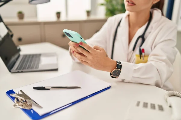 年轻的高加索女医生使用智能手机在诊所工作 — 图库照片