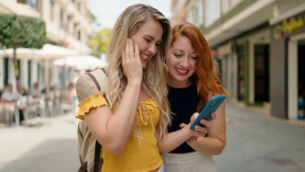 Δύο Γυναίκες Στέκονται Μαζί Χρησιμοποιώντας Smartphone Στο Δρόμο — Φωτογραφία Αρχείου