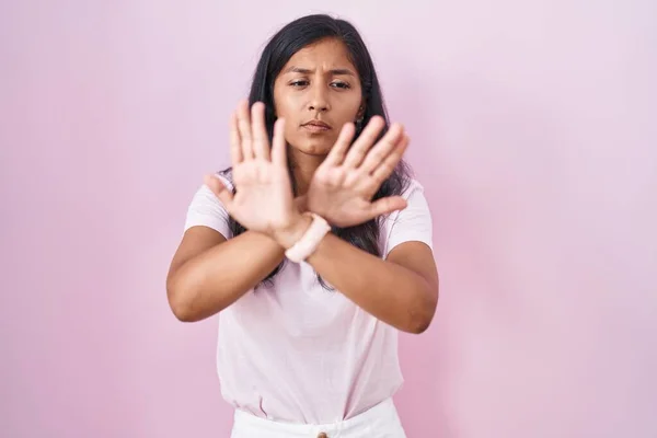 Молодая Латиноамериканка Стоящая Розовом Фоне Отторгает Выражение Лица Скрещивая Руки — стоковое фото
