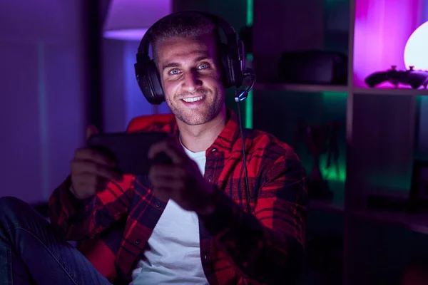 코카서스 남자는 방에서 스마트폰을 사용하여 비디오 게임을 간소화 — 스톡 사진
