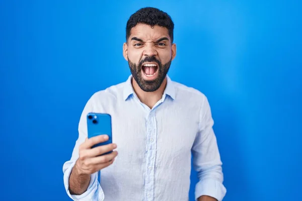 有胡子的西班牙裔男人用智能手机打字信息愤怒而疯狂地尖叫 沮丧而愤怒 愤怒地大叫 愤怒和好斗的概念 — 图库照片