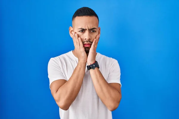 Young Hispanic Man Standing Blue Background Tired Hands Covering Face — Foto de Stock