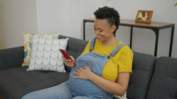 Jonge Zwangere Vrouw Met Smartphone Zittend Bank Thuis — Stockfoto