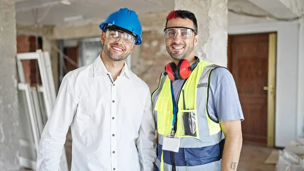 建設現場で二人の男の建築家と建築家が共に笑顔で立っている — ストック写真