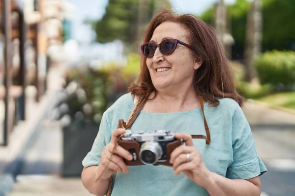 シニア女性観光客笑顔自信を持って保持カメラで通り — ストック写真
