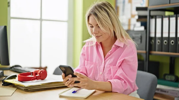 Young blonde woman business worker using smartphone working at office