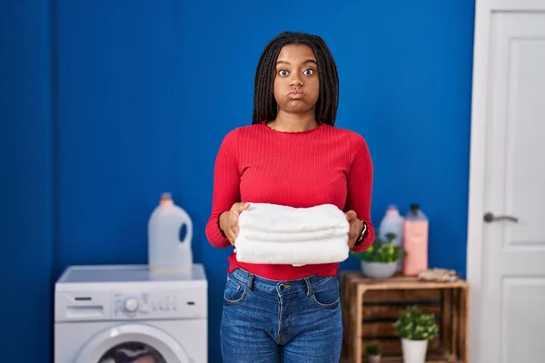 Young African American Braids Holding Clean Laundry Puffing Cheeks Funny — Stock Photo, Image