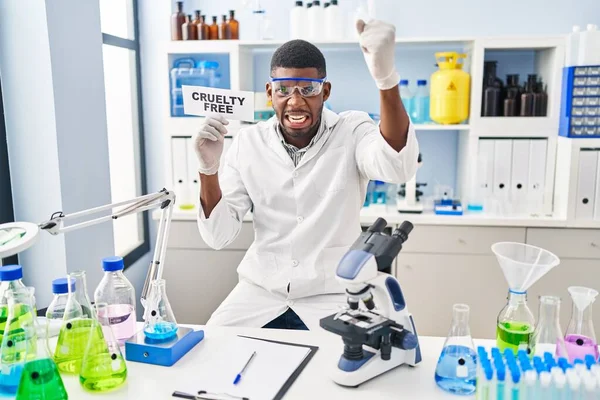 アフリカ系アメリカ人の男が研究室で残酷さに取り組んで怒りと怒りの叫び怒りと手を上げて狂気を叫んで — ストック写真