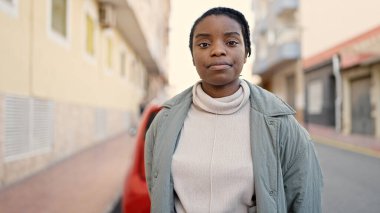 Sokakta rahat bir ifadeyle dikilen Afrikalı Amerikalı kadın.