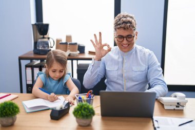 Genç baba ve kızı ofiste birlikte çalışıyor parmaklarıyla imza atıyor, gülümsüyor ve mükemmel bir sembol oluşturuyor. 
