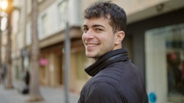 Young hispanic man smiling confident at street