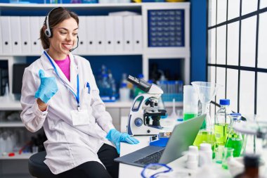 Laboratuvarda çalışan İspanyol kadın mutlu ve gururlu bir kendini işaret ediyor. 