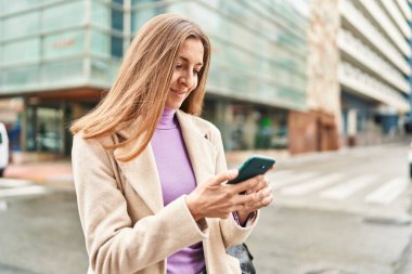 Sokakta akıllı telefon kullanan genç bir yönetici.