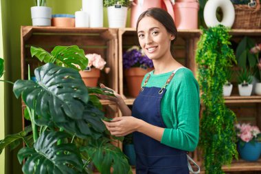 Çiçekçide kendine güvenen güzel İspanyol kadın çiçekçi.